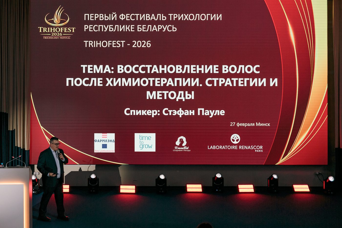 Oficiální obrazovka TRIHOFEST 2026 v Minsku ukazující Stéphana PAULETA jako řečníka o rekonstrukci vlasů po chemoterapii s logem Laboratoire RENASCOR Paris
